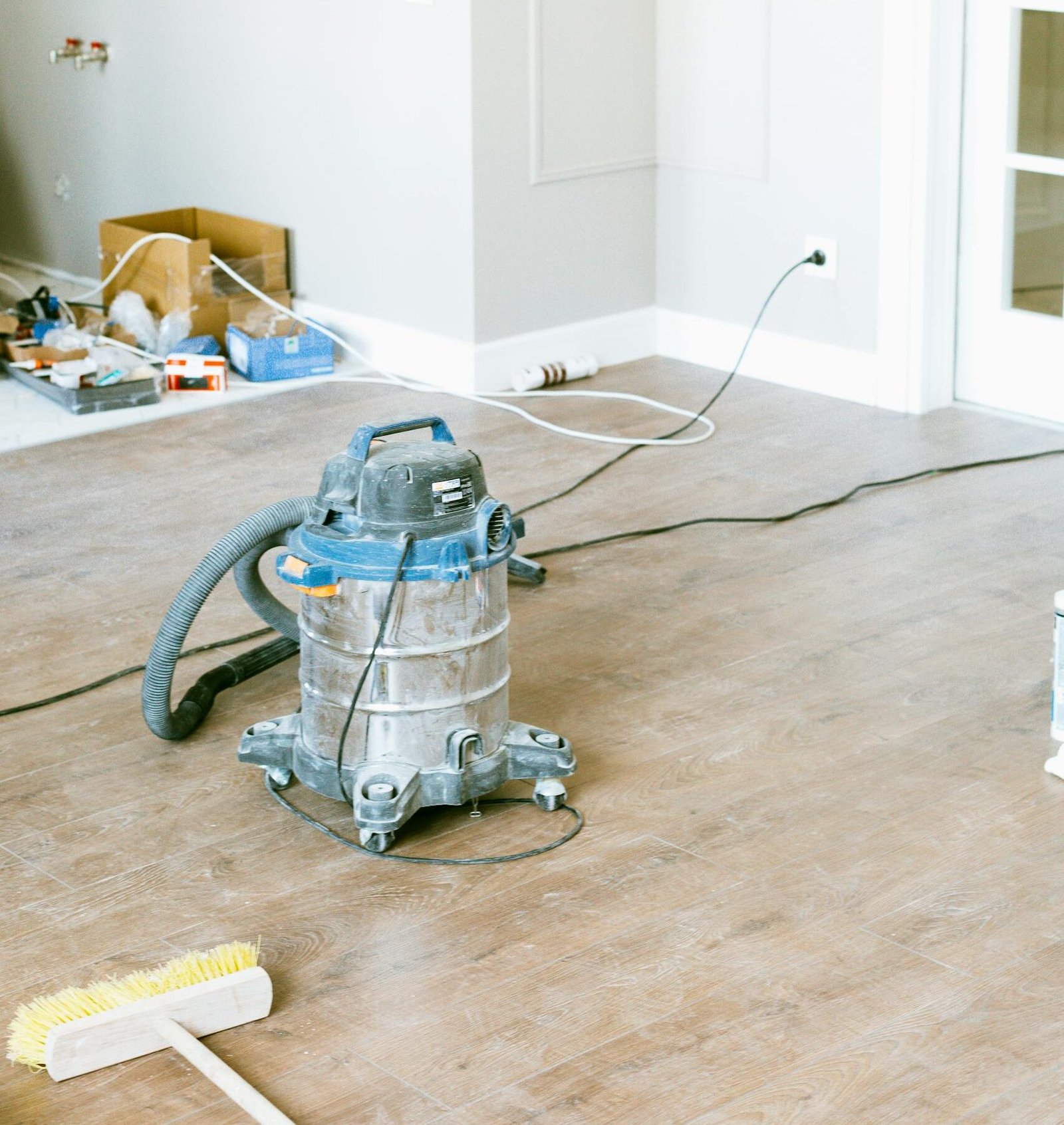 Vacuum and tools in a room undergoing renovation, showcasing home improvement.